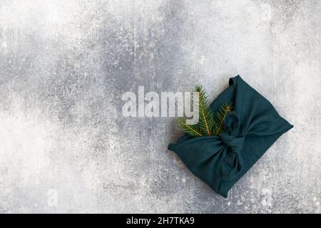 Furoshiki style gift for Christmas or New Year on a white background. Flat lay. Copy space. Stock Photo
