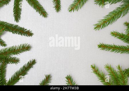 Fir branches frame on a silver colored background. Festive composition. Stock Photo
