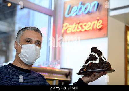 Istanbul, Turkey. 22nd Nov, 2021. A shop assistant shows a cake at the Lebon Patisserie in Istanbul, Turkey, Nov. 22, 2021. TO GO WITH 'Feature: Turks defend Istanbul's historical patisserie from closure amid COVID-19' Credit: Sadat/Xinhua/Alamy Live News Stock Photo