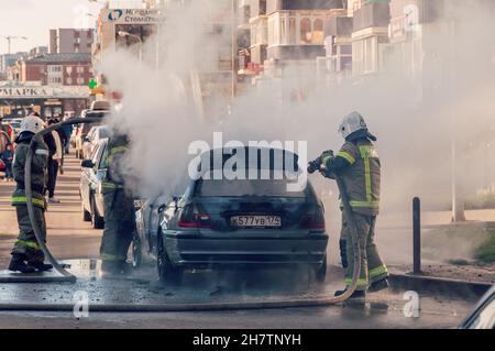 Krasnodar, Russia - November 24 2021: Firefighters attack a propane fire. Fireman Putting Out Fire. Firemen extinguishing a car fire Stock Photo