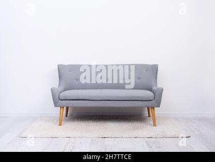 Gray sofa on carpet in light room Stock Photo