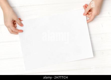 Empty blank sheet of paper in hands Stock Photo