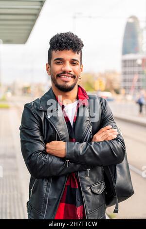 stylish young latin entrepreneur smiling looking at camera with his arms crossed, concept of urban lifestyle Stock Photo