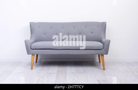 Gray couch standing on light laminate floor Stock Photo