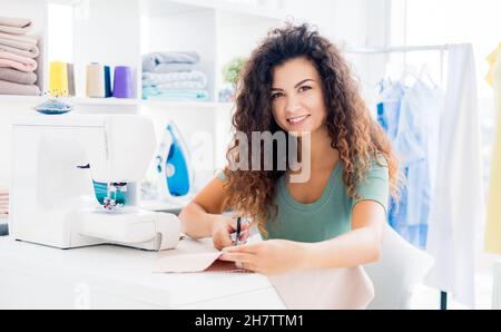 Cute girl a tailor cuts clothes Stock Photo