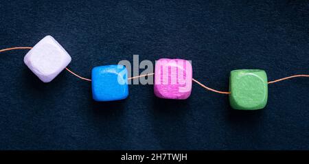 Wooden cube beads on thread Stock Photo