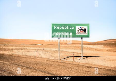 Border sign of  ' Republica de Chile ' on desert crossing road on way to Bolivia through Atacama desert mountains - Adventure travel concept Stock Photo