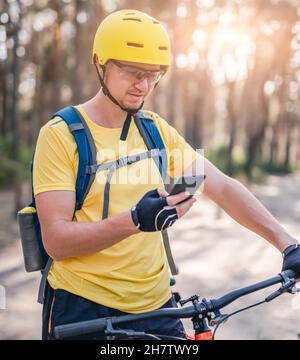Man using smartphone with map during cycling Stock Photo