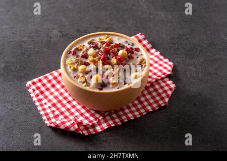 Traditional Turkish Noah's pudding in bowl on black slate background Stock Photo