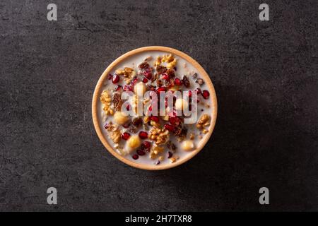 Traditional Turkish Noah's pudding in bowl on black slate background Stock Photo