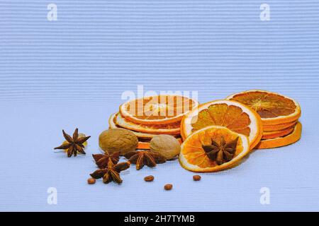 Slices of dried orange and grapefruits,nutmeg and star anise for christmas food decorations on light blue background.  Stock Photo