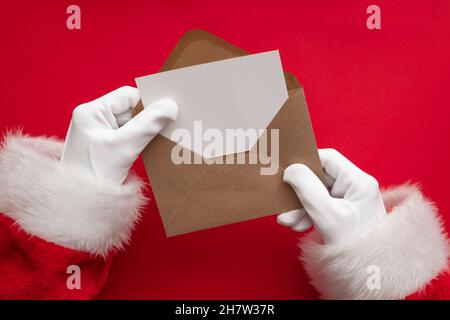 Santa Claus holding a blank Christmas card. Festive message mock up Stock Photo