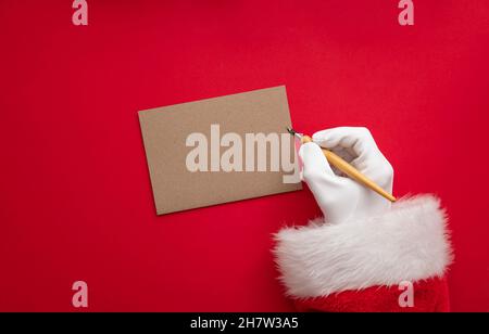 Santa Claus wiring a festive message on blank paper Stock Photo