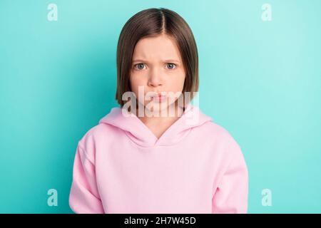 Photo of sad short hairdo small girl wear pink sportswear isolated on teal color background Stock Photo