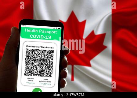 Spain. 24th Nov, 2021. In this illustrative photo a symbolic covid vaccine certificate, also called covid passport, is seen on the screen of a mobile phone with the canadian flag in the background in Barcelona, Spain on November 24, 2021. The implementation of the covid19 passport is being discussed in Canada where infections rate are increasing. (Photo by Davide Bonaldo/Sipa USA) Credit: Sipa USA/Alamy Live News Stock Photo