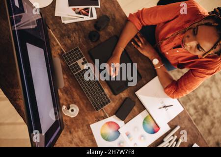 Freelancer working at her creative workstation. High angle view of a female graphic designer drawing on a digital tablet. Creative young woman working Stock Photo