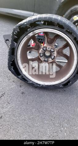 Destroyed tyre on alloy wheel, walls have disintegrated due to running a flat tyre too long too far. Both tyre walls have failed outer and inner Stock Photo