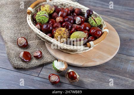 Chestnuts in a basket on a wooden background. Stock Photo