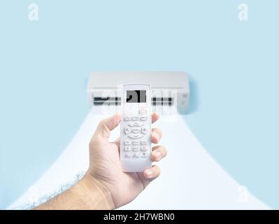 Human hand holding air conditioner remote control for regulate temperature, on the remote, there is a black blank display Stock Photo