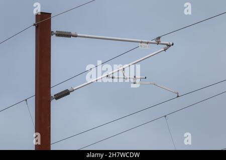 Overhead live electric railway train power supply Stock Photo