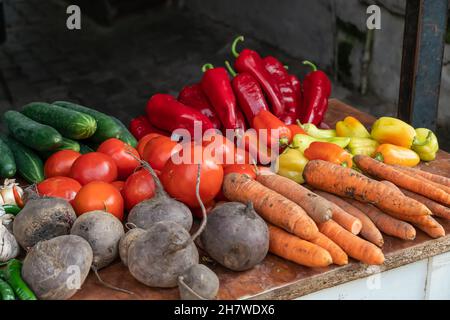 Close-up of fresh vegetables on the counter at the market. Tomatoes, peppers, cucumbers, beets, garlic, carrots, chili peppers Stock Photo
