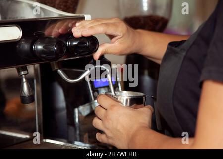 Waitress making a coffee in the coffee machines in the coffee shop. Stock Photo