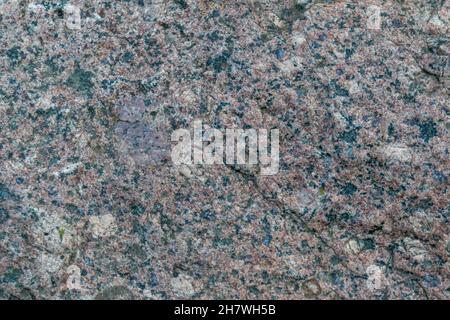 The texture of the old stone. Granite. Variegated colors, natural background. Horizontal photo. Stock Photo