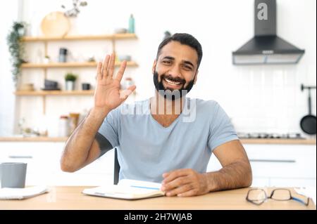 Virtual meeting concept. Head shot of a positive Indian man sits at home, looks at camera talks through video call. Male freelancer or mentor communicates to client remotely, smiles friendly Stock Photo