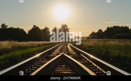 A beautiful sunset over the empty railroad and platform between ...