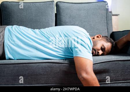 tired fat man sleeping on sofa at home - concept showing of resting, weekend holiday and exhausted due to overwork Stock Photo