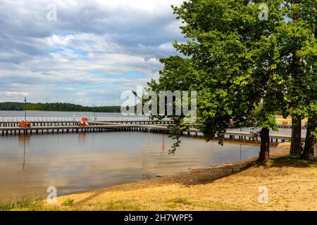 Augustow, Poland - June 1, 2021: Jetty pier and public beach at Necko lake shore in Masuria lake district resort town of Augustow in Podlaskie voivods Stock Photo