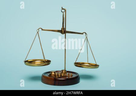 bronze justice scales on blue background, anti-corruption concept Stock Photo