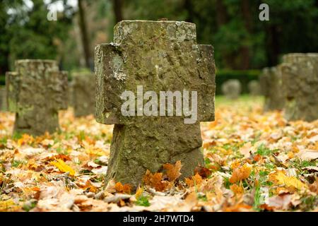 stone crosses amid colourful autumn leaves at a soldiers' cemetery in germany Stock Photo