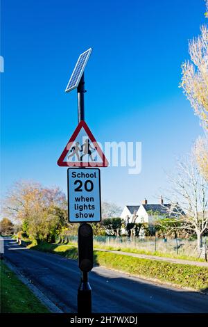 A solar powered street sign warning of a school site and promoting a 20 mph speed limit in East Hanney, Wantage, Oxfordshire, UK.