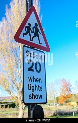 A solar powered street sign warning of a school site and promoting a 20 mph speed limit in East Hanney, Wantage, Oxfordshire, UK.