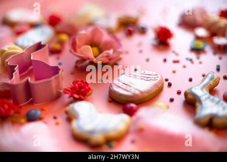 Easter cookies candies sugar sprinkles and cutters on pink, shallow dof Stock Photo