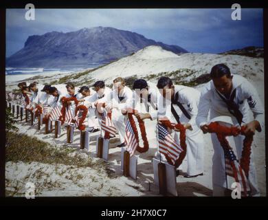 Hawaiian Islands, Spring 1942 -- Original Caption - 'In Hawaiian tradition, sailors pay tribute to casualties of the Pearl Harbor attack at a Hawaiian Islands cemetery, circa Spring 1942. Possibly taken on Memorial Day.' Photo by US Navy Stock Photo