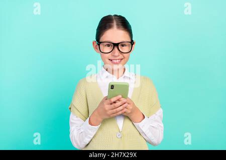 Photo of focused blogger small lady hold telephone post message wear green top isolated teal color background Stock Photo