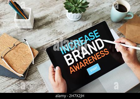 Increase brand awareness text on screen. Advertising and marketing concept. Stock Photo