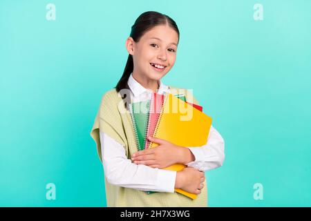 Photo of positive lady hold pile copybook look prepare school wear green top cardigan isolated teal color background Stock Photo