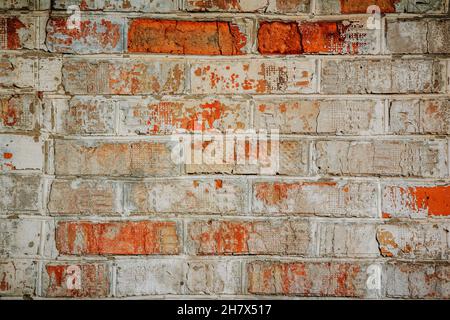 Old vintage red brick textured wall covered with peeled white paint. Abstract background Stock Photo