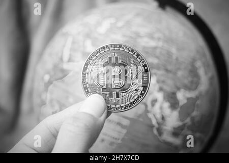 Bitcoin on background of globe with map, black and white Stock Photo