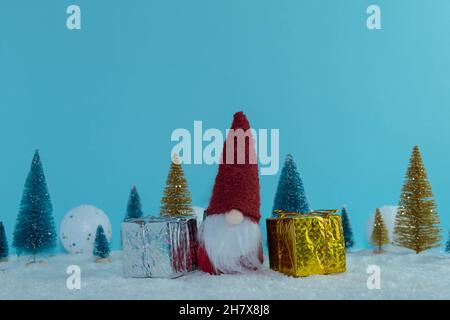 Christmas gnome with gifts in the pine forest. Magic bag. Merry Christmas. Happy New Year 2022 Stock Photo