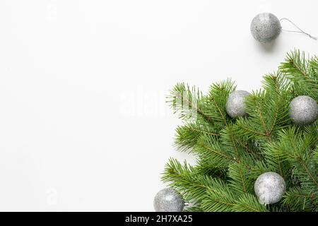 Christmas tree green branches and silver balls on a white background. Decorations for Christmas and New Year. Top view Stock Photo