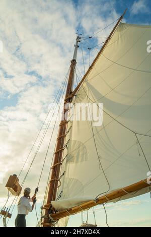 raising the sail on a historic  gaff-rigged 'Friendship' sloop Stock Photo