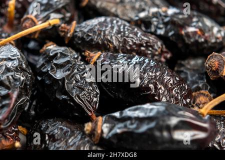 Dry rose hips. Dried wrinkled briar berries. Dog-rose fruits. Macro. Healthy ingredient Stock Photo