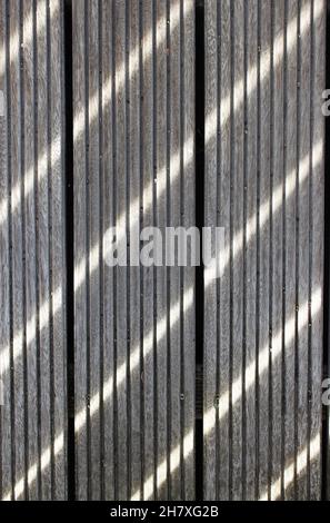 Sun rays create a pattern of lines on the wooden floor Stock Photo