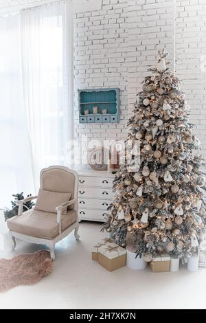 New Year's room with two huge trees and Christmas lights. Festively decorated hall for Christmas or New Year's Eve. Gifts under tree decorated with wh Stock Photo