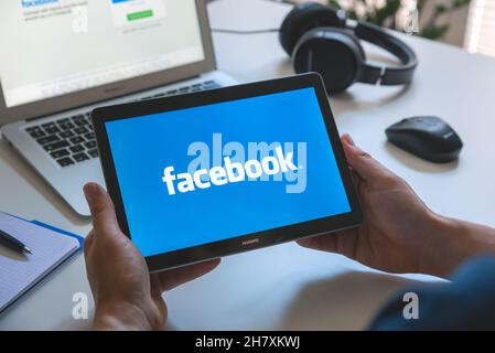 Wroclaw, Poland - JUN 17, 2021: Man using Facebook appication on Huawei MediaPad T3 tablet. Facebook is most popular social media service. Stock Photo