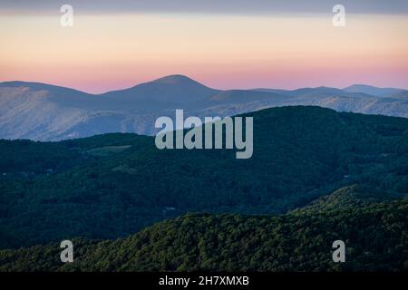 View from Sugar Mountain of sunset dusk ridge layers and peaks in North Carolina Blue Ridge Appalachias with silhouette, trees and pastel color Stock Photo